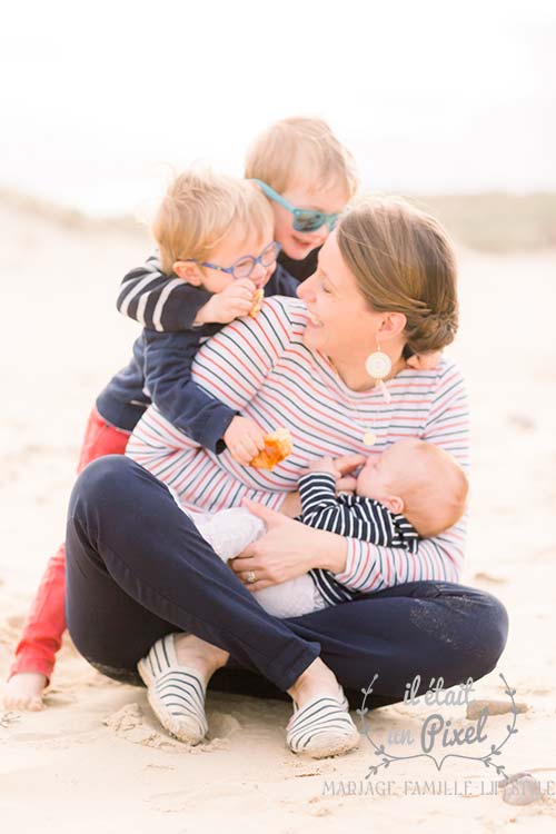 Portrait lifestyle sur le vif d'enfants jouant avec leur mère sur la plage du Veillon en Vendée pendant un shooting photo famille