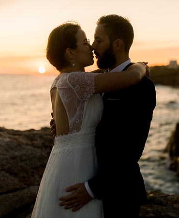 Newly wed couple kissing at sunset on the French seaside of Vendee